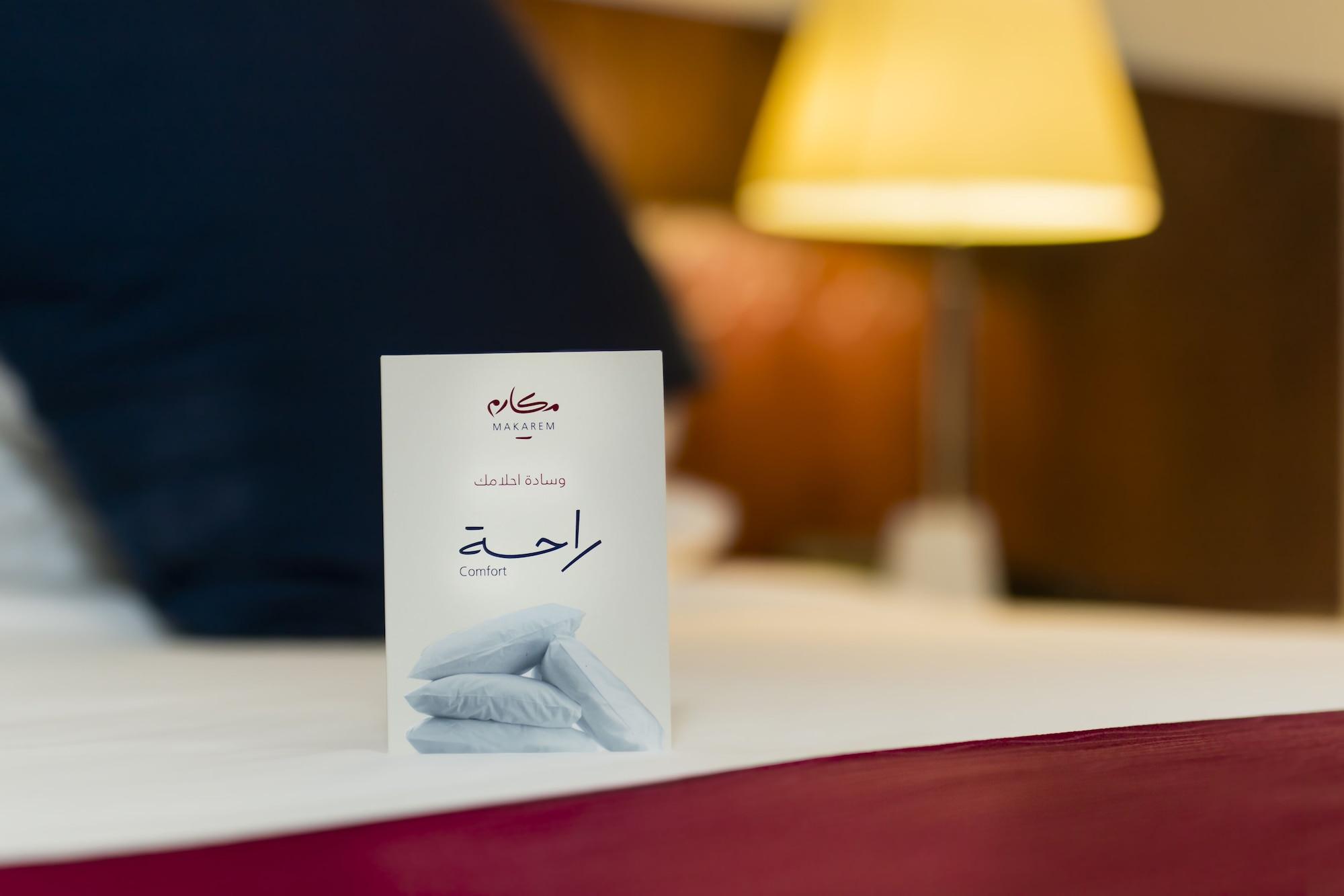 โรงแรมมากาเรม อุมม์ อัลกุรา Mecca ภายนอก รูปภาพ The photo shows a neatly arranged hotel bed with a white card placed in the foreground. The card features an elegant design, likely indicating a message or information related to the hotel. The Arabic word "راحة" is printed on it, which translates to